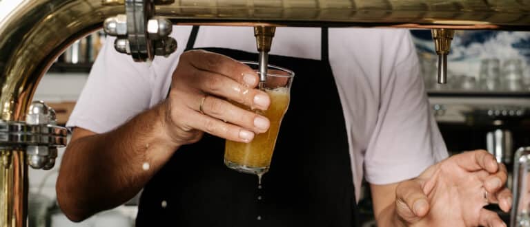 A barman pours a draft beer