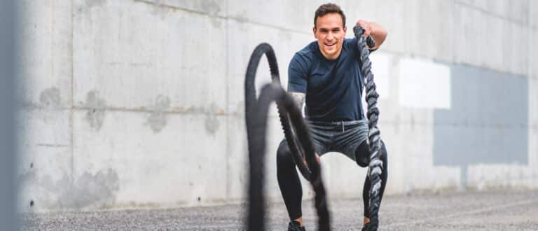 a man using battle ropes to workout