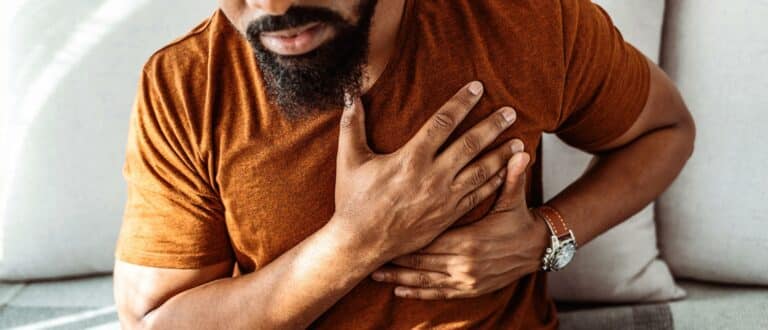 A man grabs his chest during an anxiety attack
