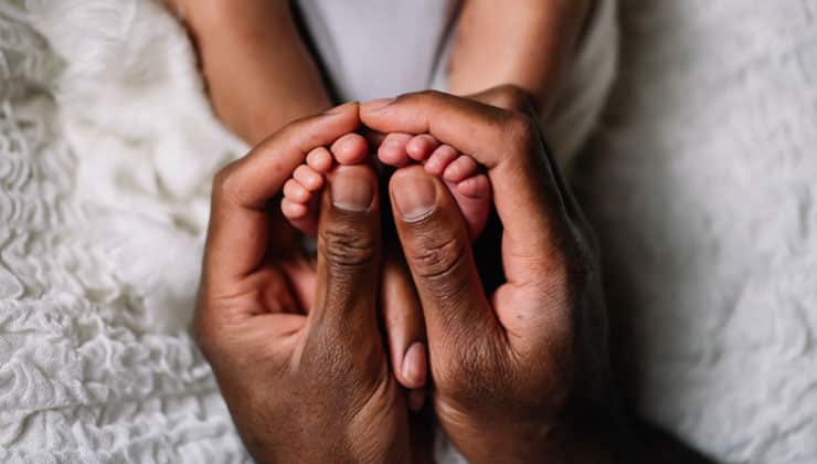 Hands holding young infants feet