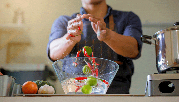 man mixing peppers and limes in bowl