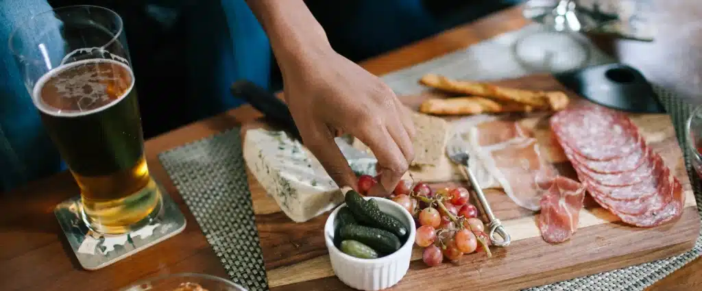 man reaching for snacks on charcuterie board