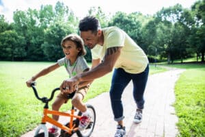 dad teaching his son to ride a bike