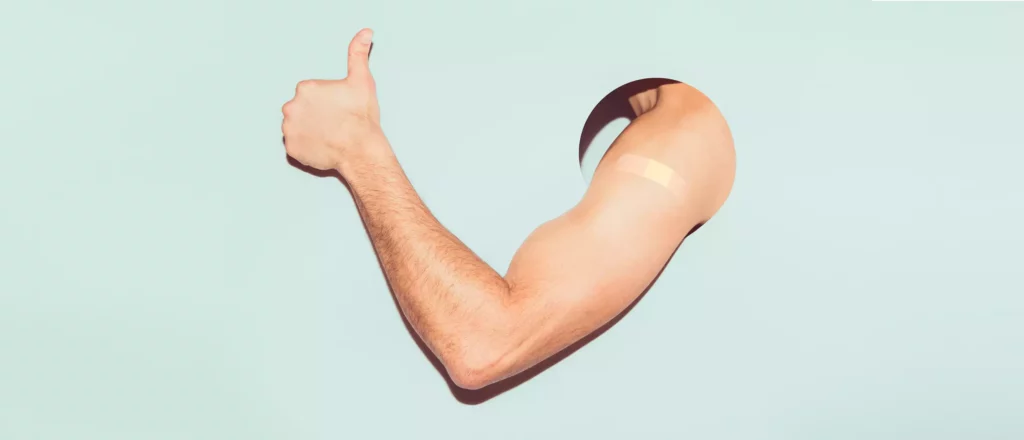 a man flexes his arm, which has a bandage on it