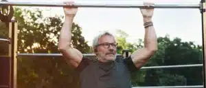 An older man does a pull up