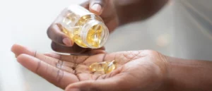 man pouring vitamin D capsules into hand