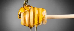 honey dripping from honey dipper