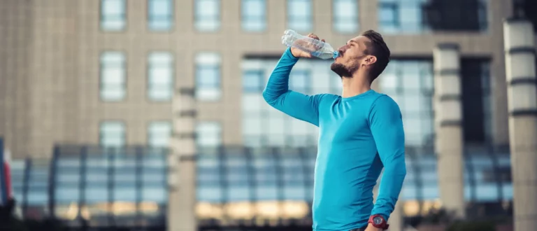 guy drinking from water bottle while working