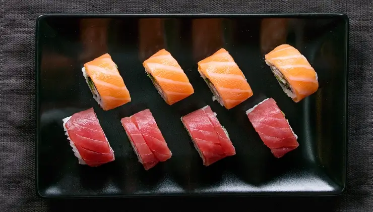 Overhead shot of salmon and tuna sushi rolls on plate
