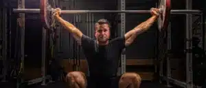 man doin overhead press with barbell