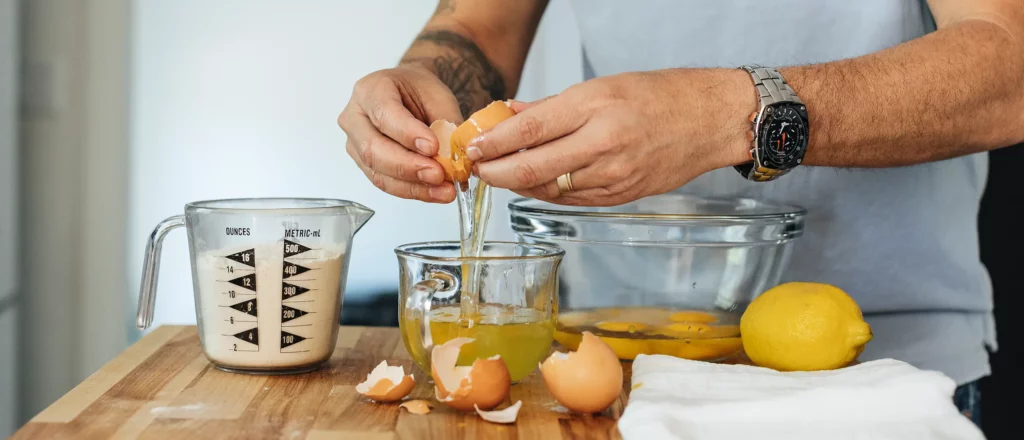 man separating egg whites from egg yolks