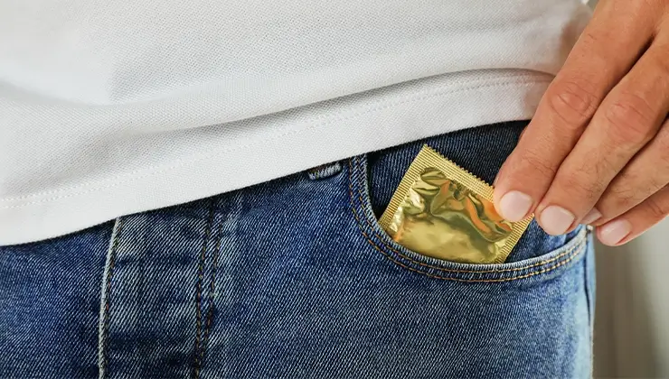 man pulling condom out of pocket