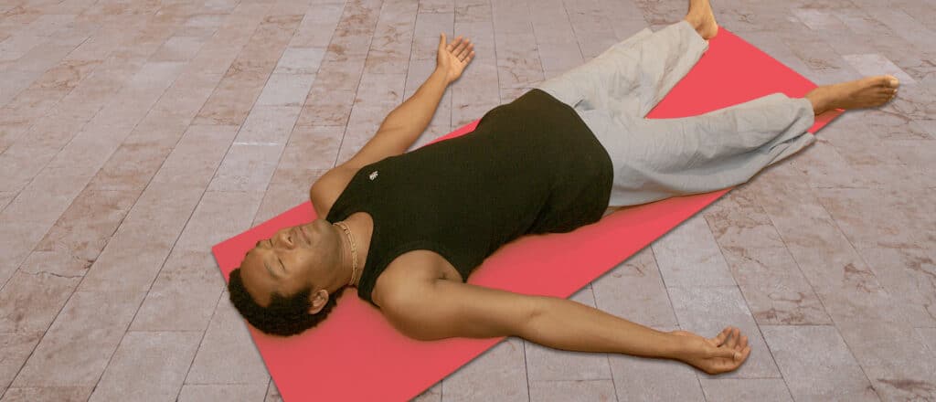 man laying down on red yoga mat