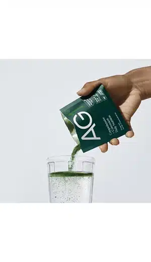 Athletic Greens packet poured into glass of water