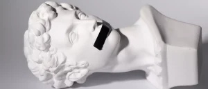 A bust lying on its side with black tape over its mouth