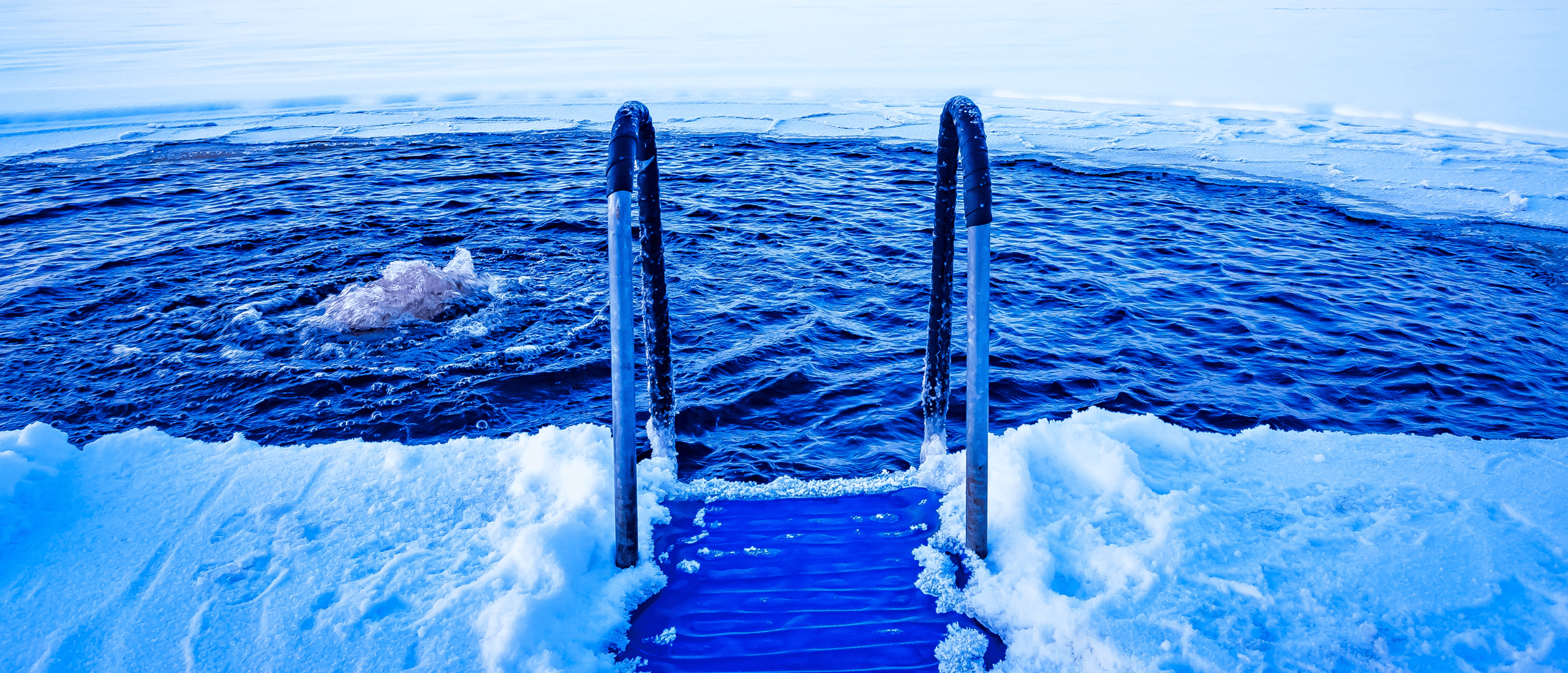 A ladder drops into an icy lake
