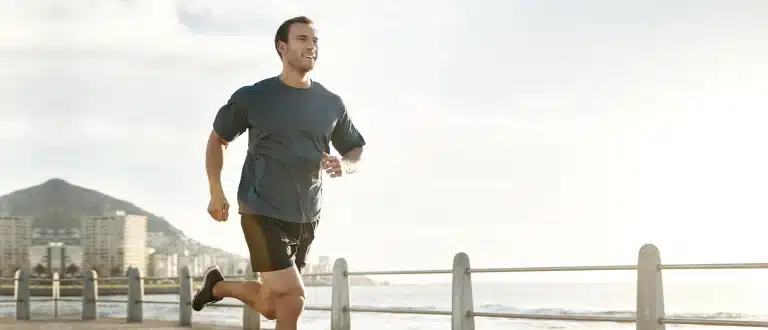 man running next to ocean