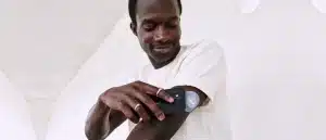 Man holding phone to blood glucose monitor on arm