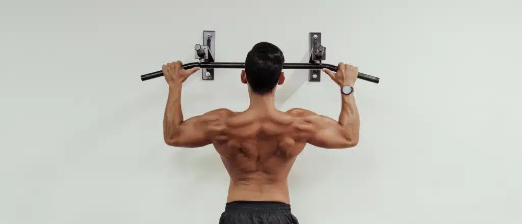 Man doing pull up on wall-mounted pull-up bar