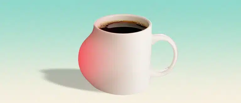 coffee cup filled with coffee with an inflammatory bump on the side.