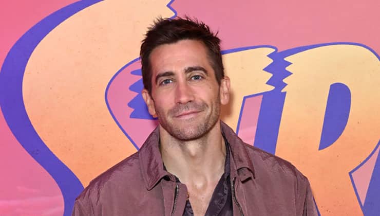 Jake Gyllenhaal standing in front of backdrop