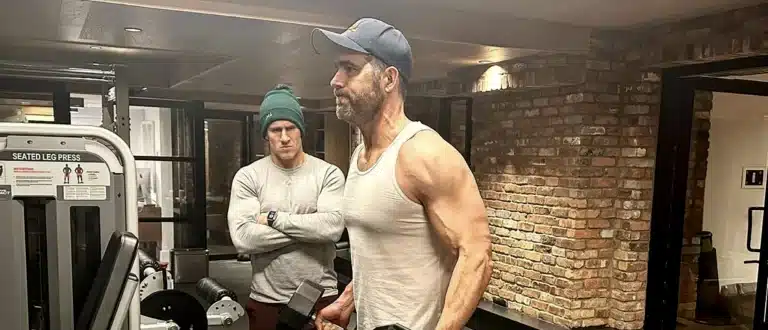 Ryan Reynolds working out in gym with trainer