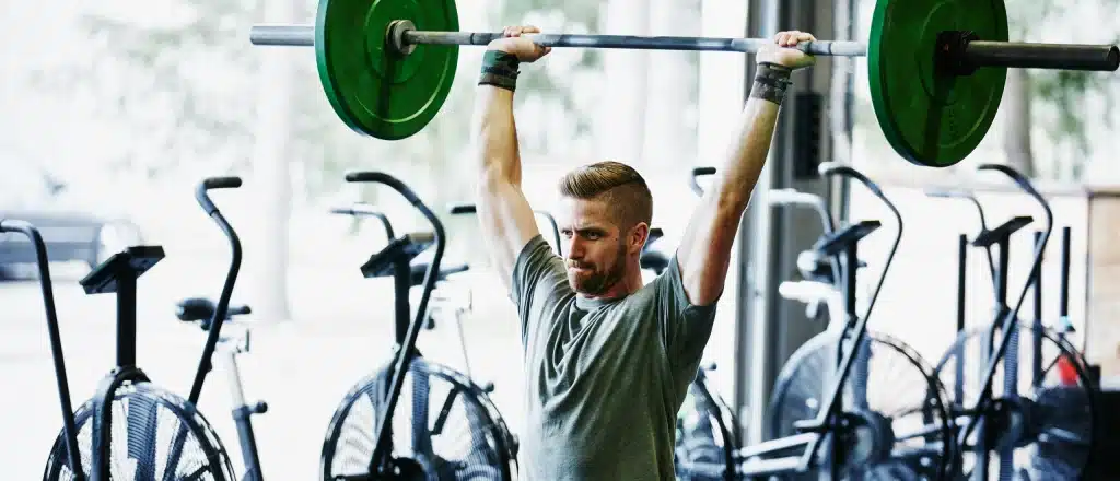 Man lifting barbell weight over head