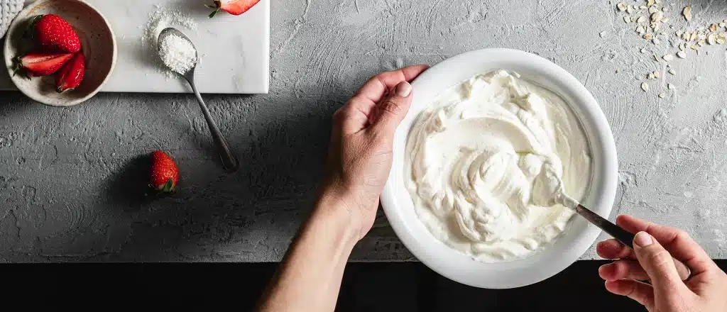 man making protein fluff with protein powder and strawberries