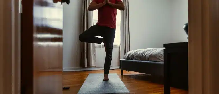 man doing a balance test, balancing on one foot in tree pose