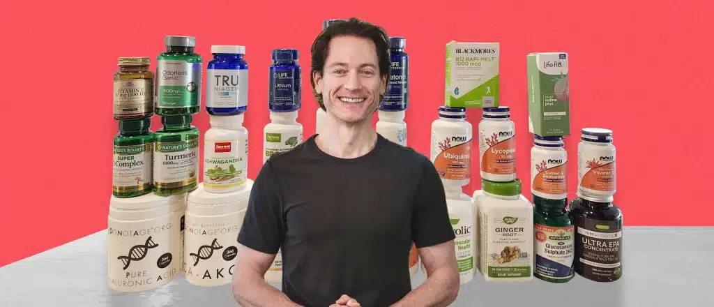 Bryan Johnson Standing in front of table with different supplements stacked up high