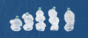Five crumpled water bottles on a blue background