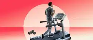 Man walking on treadmill with dumbbells sitting off to the side