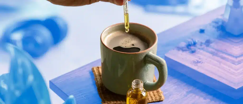 adding MCT oil to a steamy cup of coffee