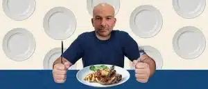 Peter Attia with a hearty meal on his plate, ignoring the empty plates behind him.