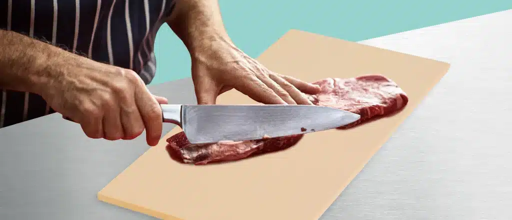 Man slicing steak on rubber cutting board