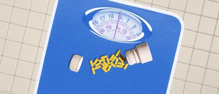 Yellow pills spilled on a blue scale