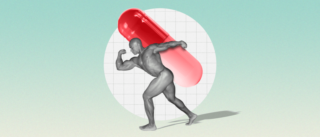 Man flexing and holding a large pill capsule on his back