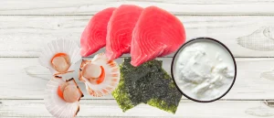 tuna, shellfish, nori, and yogurt on wood background