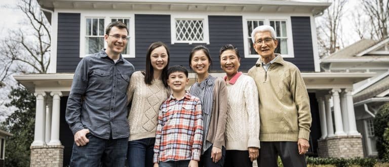 multi-generational family posing for a picture outside of home