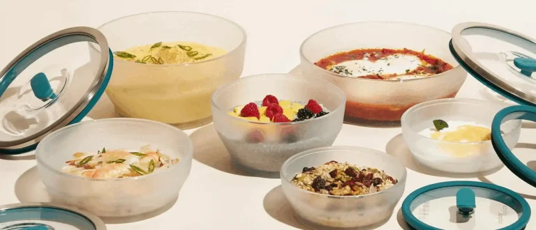 Anyday cookware bowls loaded up with different meals like chia seed pudding, shakshuka, and mashed potatoes with the lids popped off to show off the food.