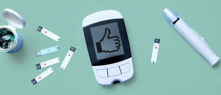 a continuous glucose monitor with a thumbs up emoji on the screen
