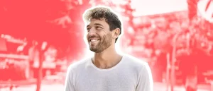 man smiling with a red background because he supplements magnesium