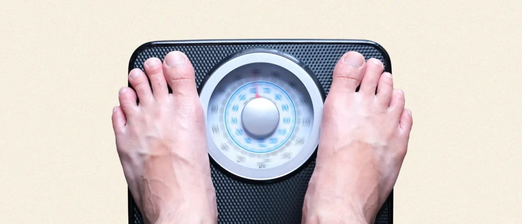 Man standing on weight scale with numbers spinning