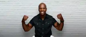 Terry Crews Flexing biceps in front of brick wall