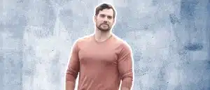 Henry Cavill posing in fron of blue textured background